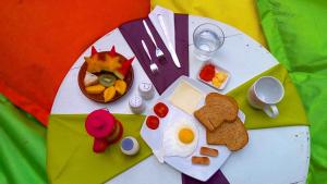 a table with a plate with breakfast foods on it at The Patio Yogya in Yogyakarta