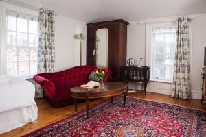 a living room with a red couch and a table at The Historical Harcourt Suites in Dublin