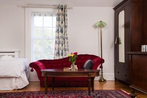a living room with a red couch and a table at The Historical Harcourt Suites in Dublin +20 photos