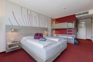 a bedroom with a large white bed with a backpack on it at Serways Hotel Remscheid in Remscheid +6 photos