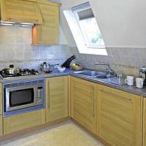
a kitchen with a stove, microwave, sink and dishwasher at Waterside Cornwall in Bodmin
