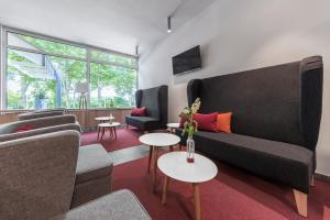 a living room with a couch and chairs and tables at Serways Hotel Remscheid in Remscheid