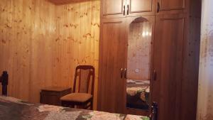 1 dormitorio con 1 cama, armario y silla en Частный сектор, en Sukhum