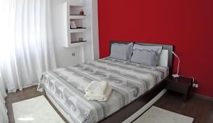 a bedroom with a bed with a red wall at TOP CENTER LUXURY Apartment in Gabrovo