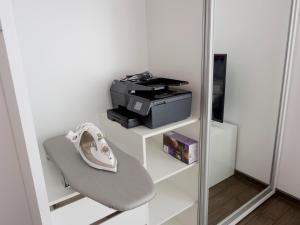 ein Regal mit einem Drucker und einem Stuhl in einem Zimmer in der Unterkunft TOP CENTER LUXURY Apartment in Gabrowo