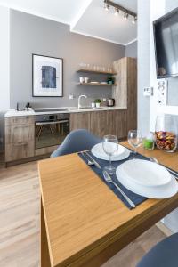 a dining room table with two white plates on it at Friendhouse Apartments Avenue in Krakow