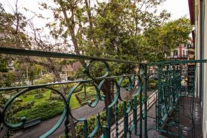 balcone con ringhiera verde e alberi di The Wine Lodges a Funchal