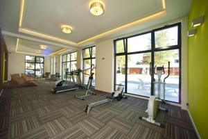 a gym with several exercise equipment in a room with windows at Apartament Sun & Sand Polanki in Kołobrzeg