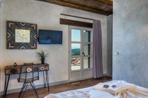 a bedroom with a bed and a table and a window at Listen to Nature in a Renovated Traditional Hilltop Villa Liodosifis with Heated Pool in Païdhokhórion +15 photos