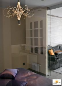 a bedroom with a bed and a chandelier at Apartament Sun & Sand Polanki in Kołobrzeg +21 photos