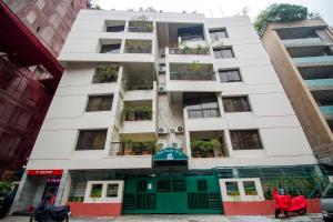 un edificio blanco alto con una entrada verde delante de él en Asia Pacific Hotel en Dhaka