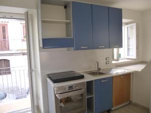 une cuisine avec des placards bleus, un évier et une fenêtre dans l'établissement Casa Gio', à Pizzo