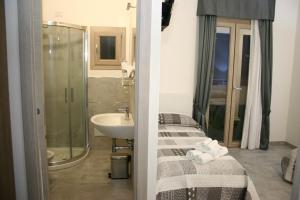 a bathroom with a bed and a sink and a shower at Il Borgo in Castelsardo +68 photos