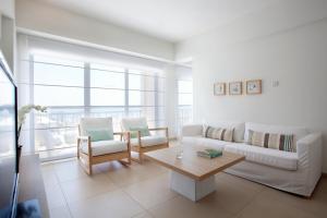 a living room with a couch and chairs and a table at Sandy Beach Hotel & Spa - ex Sentido in Larnaca