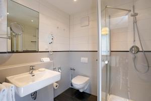 a bathroom with a toilet and a sink and a shower at Hotel Stadt Hannover in Göttingen +25 photos