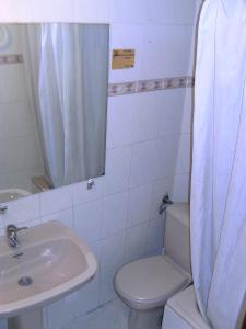 y baño con aseo blanco y lavamanos. en Hostal Alicante en Granada