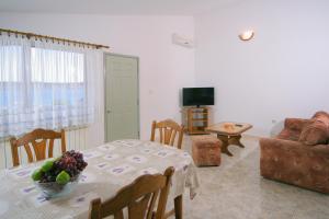 una sala de estar con una mesa con un bol de fruta. en Apartments Daniela en Trogir