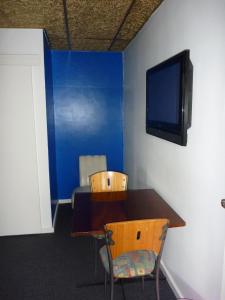 
a room with a table and chairs and a television at Adelaide Travellers Inn Backpackers Hostel in Adelaide
