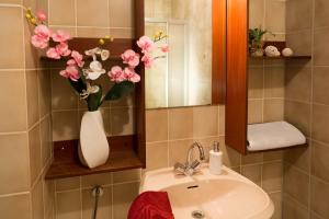 La salle de bains est pourvue d'un lavabo et d'un vase de fleurs. dans l'établissement Ferienanlage Bäckerwiese, à Neuschönau