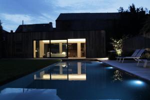 une maison avec une piscine en face de celle-ci dans l'établissement B&B For 2-Wellness For 2, à Bruges