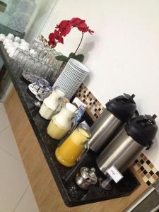 a table with candles and a vase with a flower at Arym Hotel in Aparecida do Taboado