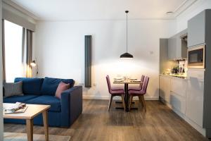 sala de estar con sofá azul y mesa en Cityroomz Edinburgh, en Edimburgo