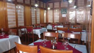 un restaurante con mesas y sillas y copas de vino en Hotel Tantzi en Sinaia