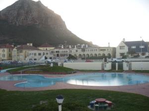 a large swimming pool with a mountain in the background at Royal at Sea in Muizenberg