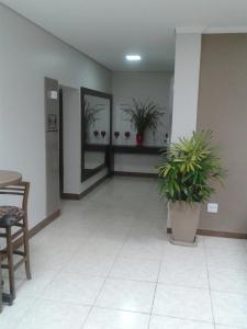 um corredor com vasos de plantas num edifício em Botucatu Hotel em Botucatu