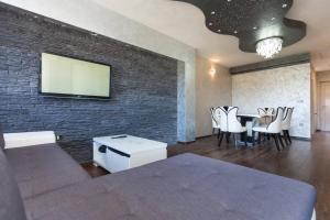 a living room with a tv and a table with chairs at Teo Apartment in Pula