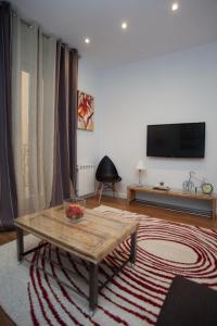 een woonkamer met een tafel en een flatscreen-tv bij Sol Gran Vía in Madrid