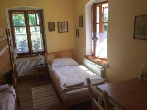 Božanov的住宿－Rekreační dům u Marušky，一间卧室设有两张床、一张桌子和两个窗户。