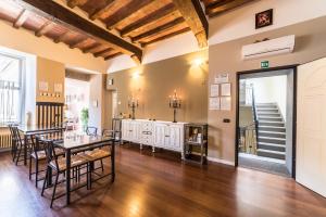 a living room with a table and chairs and a staircase at Domus San Martino GuestHouse in Piacenza