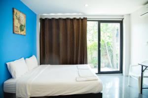 une chambre avec un grand lit avec une grande fenêtre dans l'établissement Varinda Hostel, à Bangkok 38 autres photos