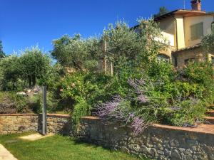 a retaining wall in front of a house with plants at Fonte Pace Luxury Villa - a Fontanaro Property in Paciano