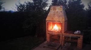 una chimenea de ladrillo con fuego por la noche en Casa El balcón de Iria, en Otero de Herreros
