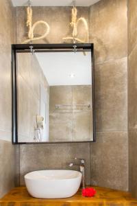 a bathroom with a large mirror and a sink at Hotel Hellas in Ancient Epidauros +50 photos