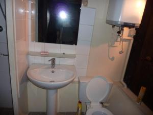 uma pessoa a tirar uma fotografia de uma casa de banho com um lavatório e um WC em Commanderie des Templiers em Figeac