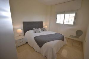 1 dormitorio con 1 cama, 1 silla y 1 ventana en Residential Duquesa, en San Luis de Sabinillas