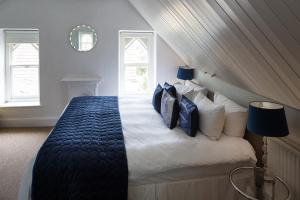 a bedroom with a bed with blue and white pillows at Norbury House Stylish Accommodation in Ilfracombe