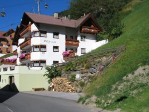 a white building on a hill next to a road at Villa Ilse in Kappl
