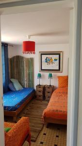 a bedroom with two beds and a red lamp at Villa Akwaba in Pyla-sur-Mer