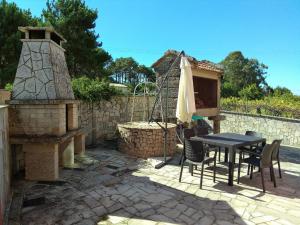 a patio with a table and an outdoor oven at Casa Rural Oscar in Baiona