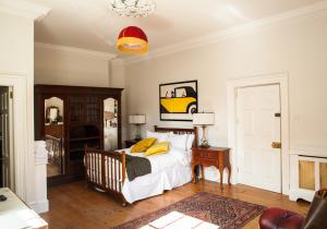a bedroom with a bed with yellow pillows on it at The Historical Harcourt Suites in Dublin