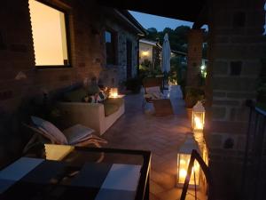 un patio con sofá, mesa y luces en Villa Isotta, en Trevignano Romano