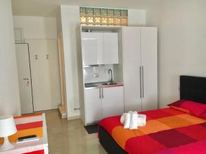 ヴェローナにあるValverde 32のベッド1台付きの部屋、白いキャビネット付きのキッチン