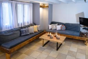 a living room with a blue couch and a table at Cozy Residences in the center of Volissos Village - Lydia Lithos- in Volissos