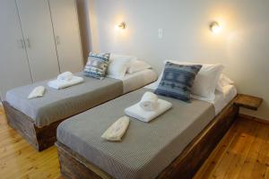 two beds with towels on them in a room at Cozy Residences in the center of Volissos Village - Lydia Lithos- in Volissos