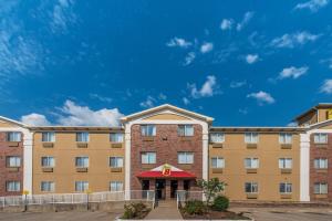 a large tan building with a red roof at Super 8 by Wyndham Denton in Denton