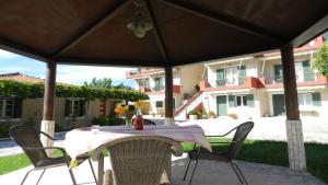 a table and chairs under an umbrella on a patio at Filoxenia Kontogiannis in Lazaráta